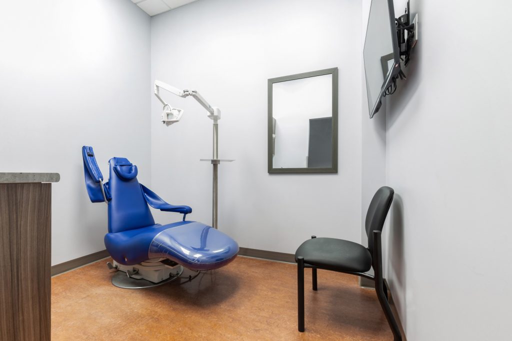 Exam room with TV on wall at St. Albert denture clinic